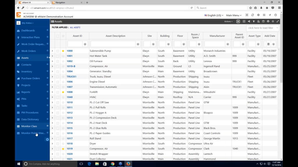 Image of eMaint CMMS asset management dashboard displaying asset IDs, descriptions, locations, manufacturers, types, and associated metadata in a tabular format.